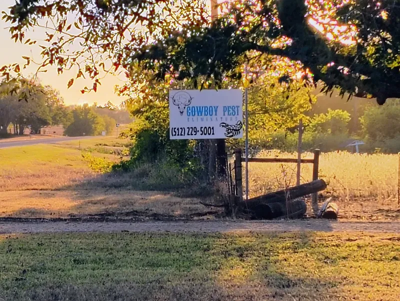 Cowboy Pest Eliminators sign at golden hour